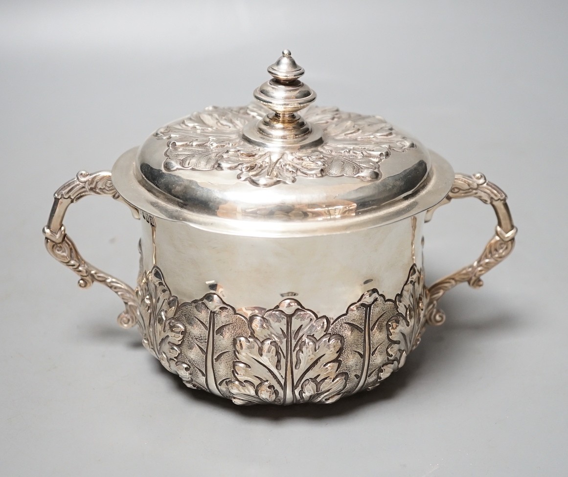 A George V embossed Brittania standard silver two handled presentation bowl and cover, Carrington & Co, London, 1916, diameter 18.6cm over handles, 18.5oz.